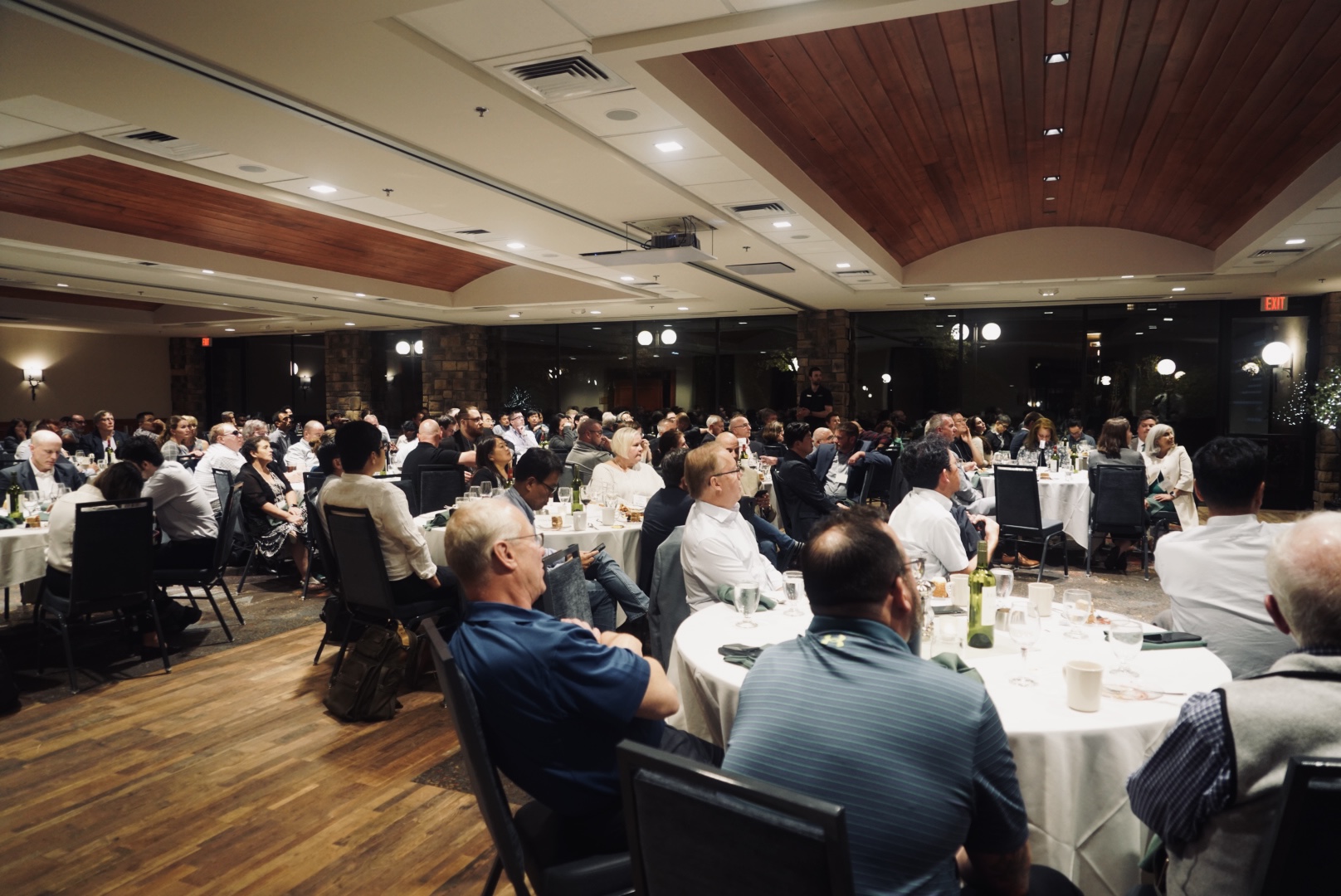 CMP Symposium attendees seated at tables taking in a presentation