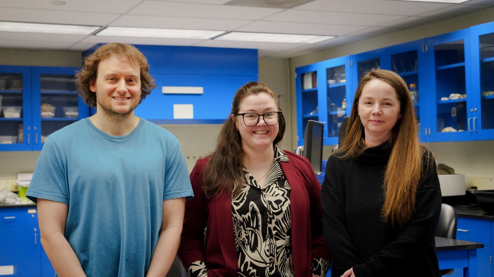 From left, one man and two women who work on Milfoil monitoring research, stand and smile for a photo inside a laboratory