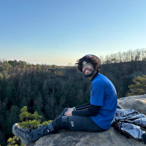 A photo of Bernard Carroll sitting on top of a mountain.