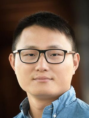 Shoulders-up close-up of Yang Yang in light blue open-collared shirt.