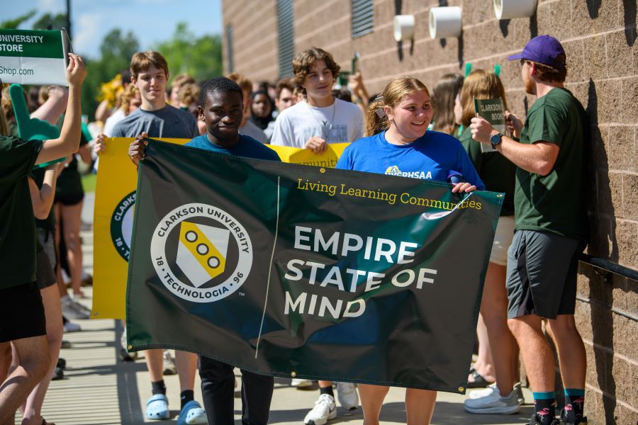 A photo of the fall 2024 empire state of mind living learning community holding a banner