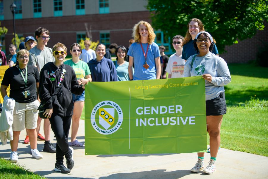 A photo of the fall 2024 gender inclusive living learning community holding a banner