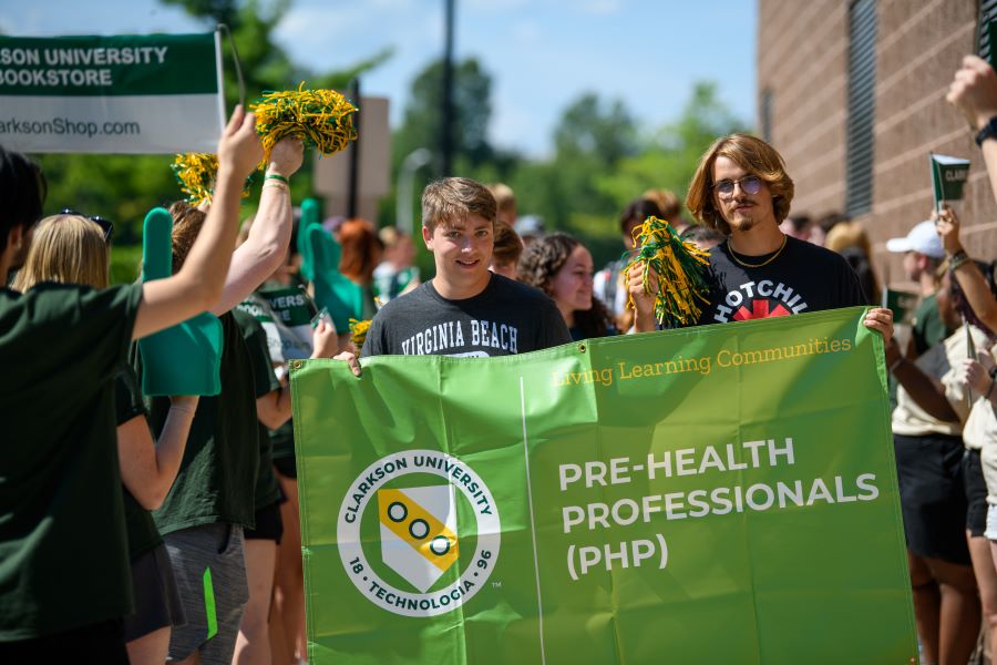 A photo of the Fall 2024 pre health professionals living learning community holding a banner