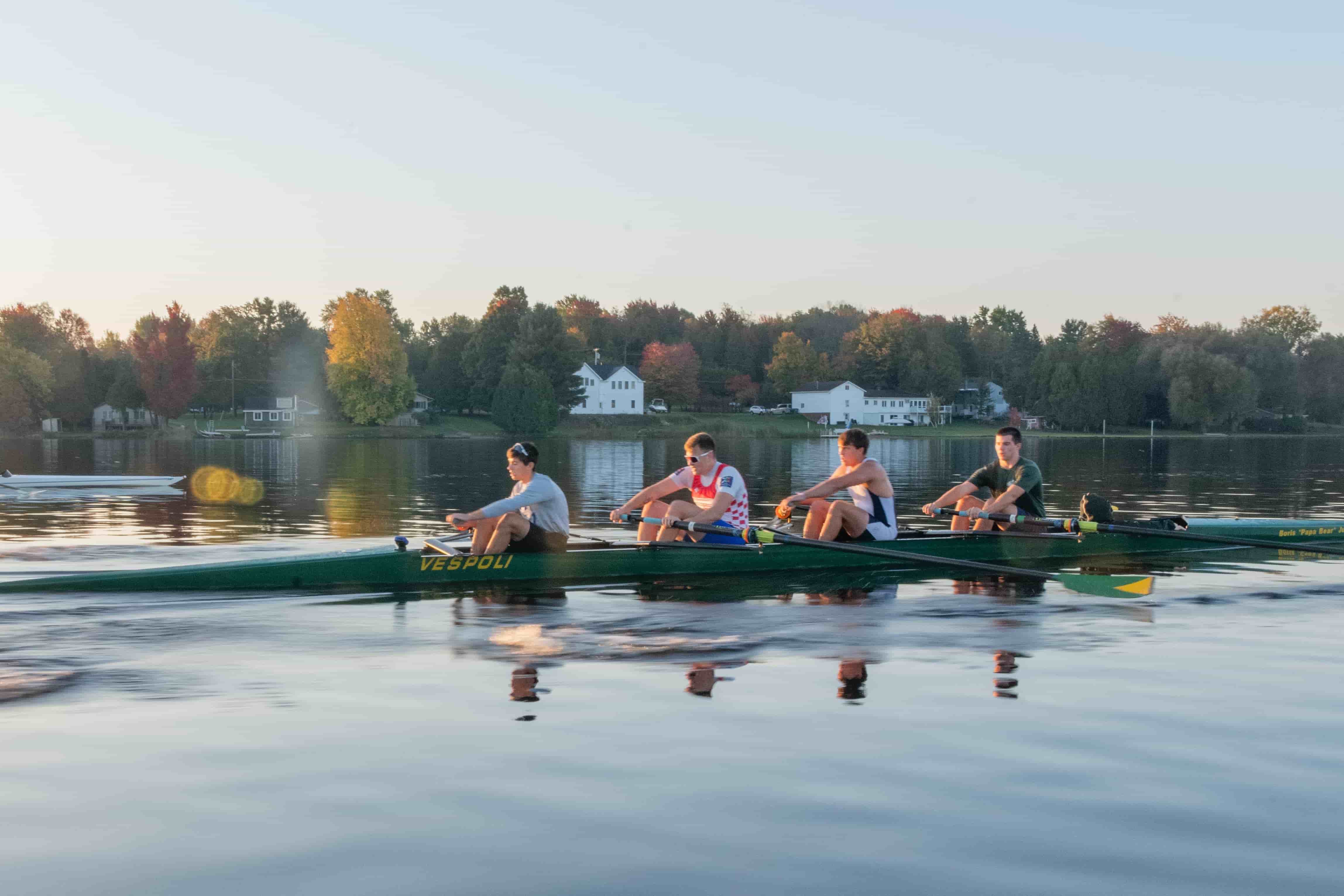 The Clarkson CREW team rows on a scenic body of water