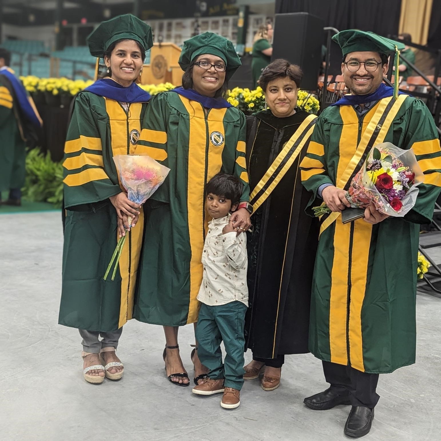 A photo of Sumona Mondal and her three graduate students in commencement regalia. 
