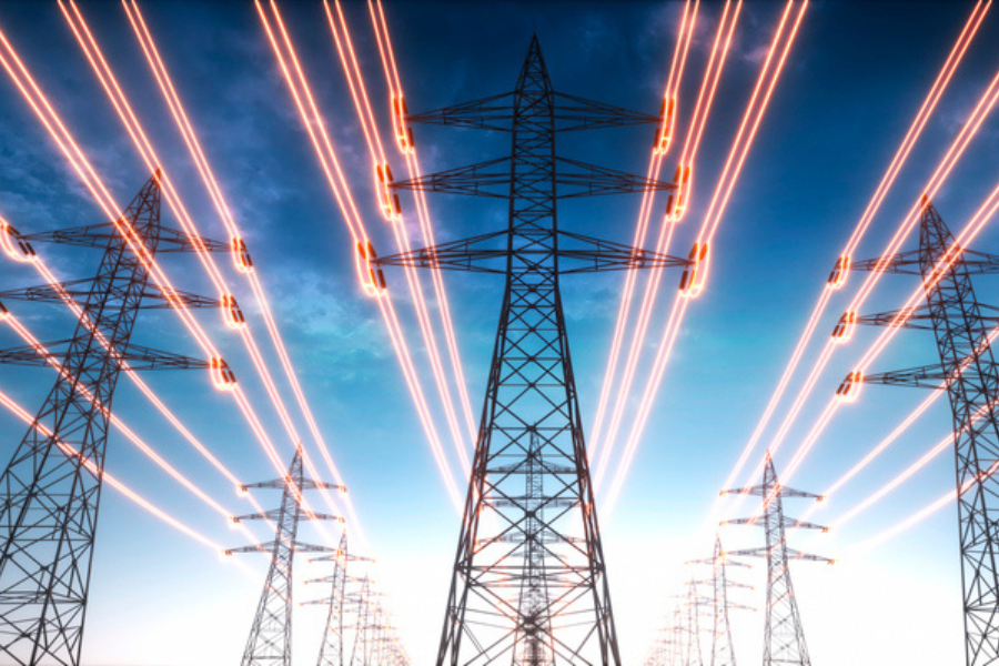 Rows of high-voltage power lines stretching into the distance, with glowing transmission lines against a backdrop of a darkening sky. The image represents energy transmission and the power grid.