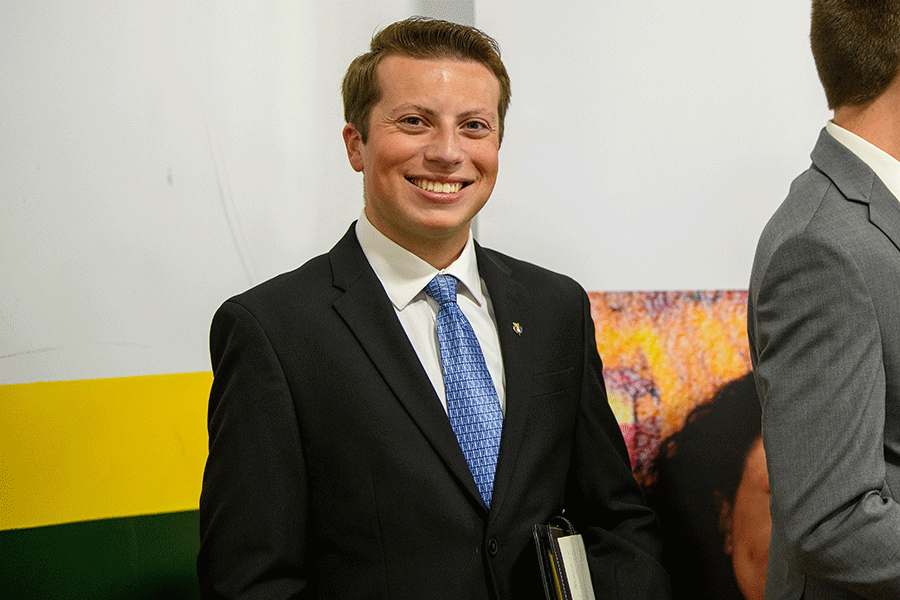 Clarkson student Miles Compani smiles at the camera while wearing a suit and tie