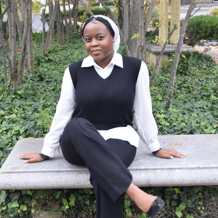 Niyogushima Nuru sitting on a park bench surrounded by nature