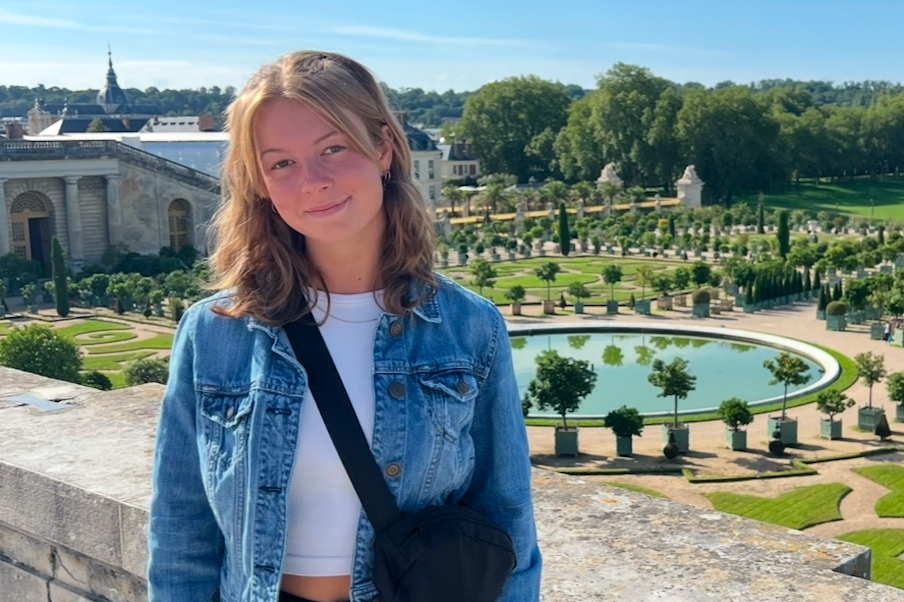 Female student in front of beautiful setting.