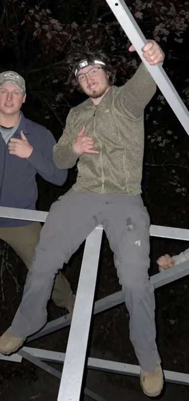 Male student climbing some structure.