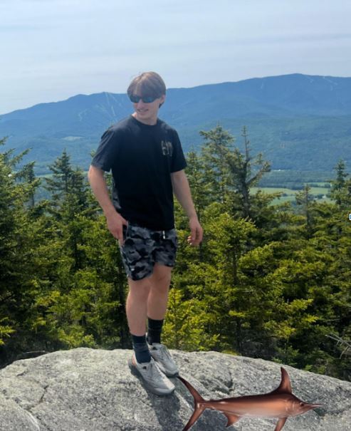 Male student on top of mountain