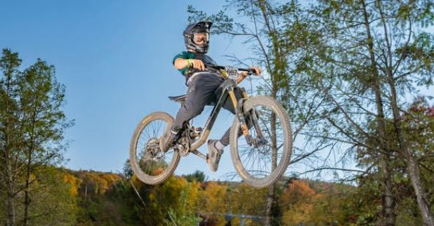 Male student jumping with bike.