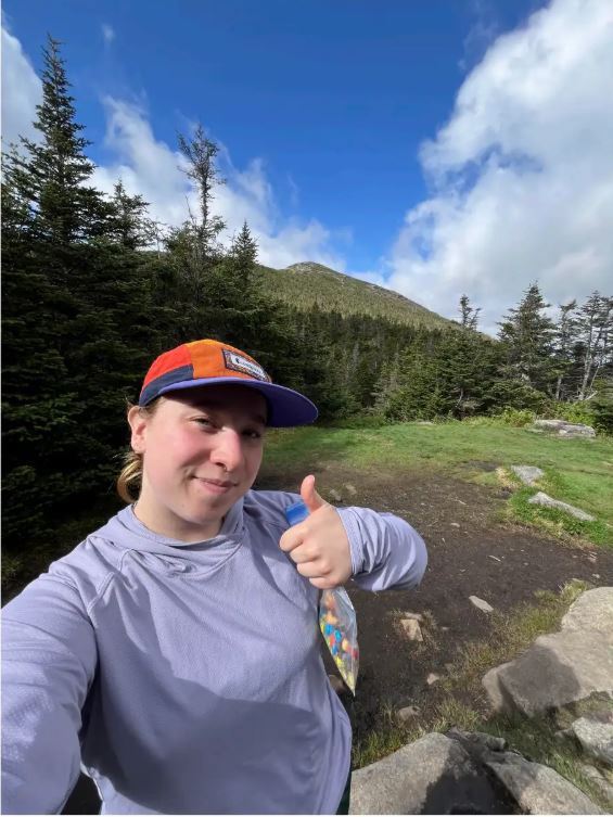Girl on hiking trail giving thumbs up
