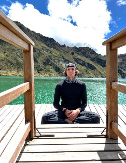 Male student posing in front of lake.