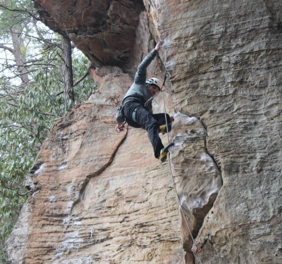 Male student rock climbing.