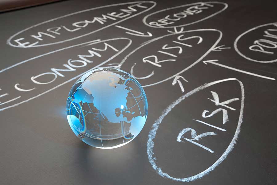 Globe on a chalkboard with risk terms written on it