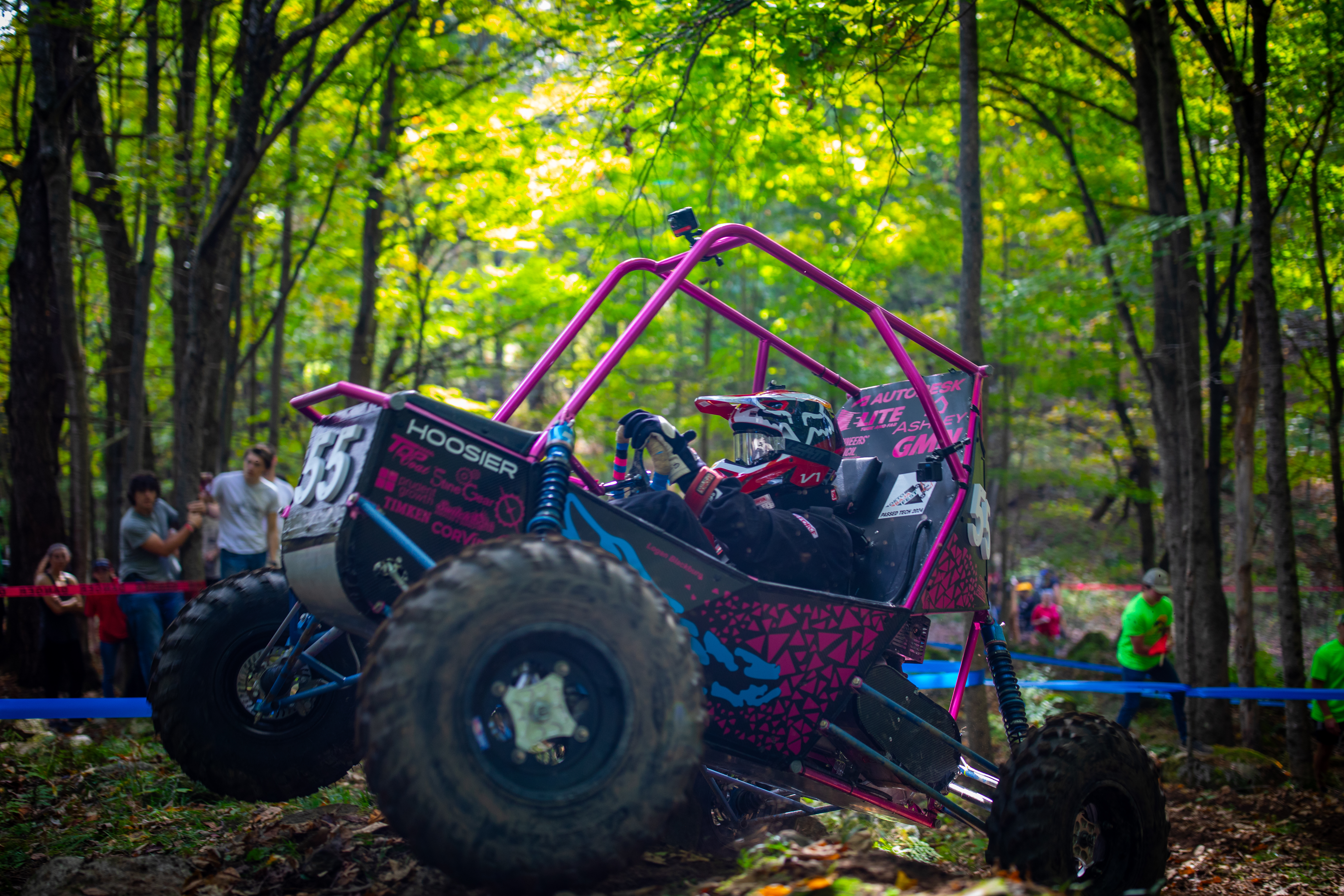 a BAJA buggy navigates rough terrain in the forest
