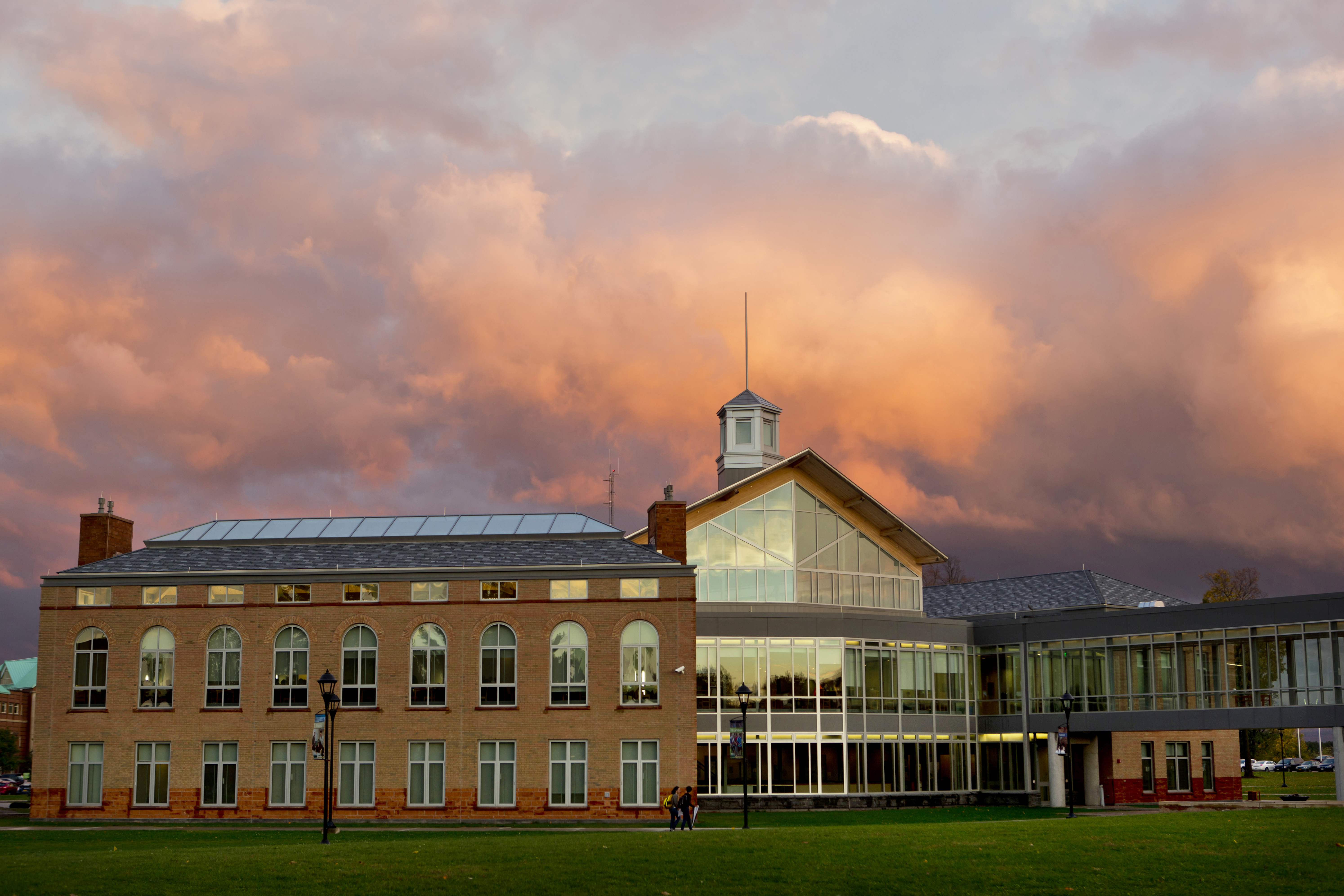 Clarkson University's student center at dawn with glowing clouds in the background.