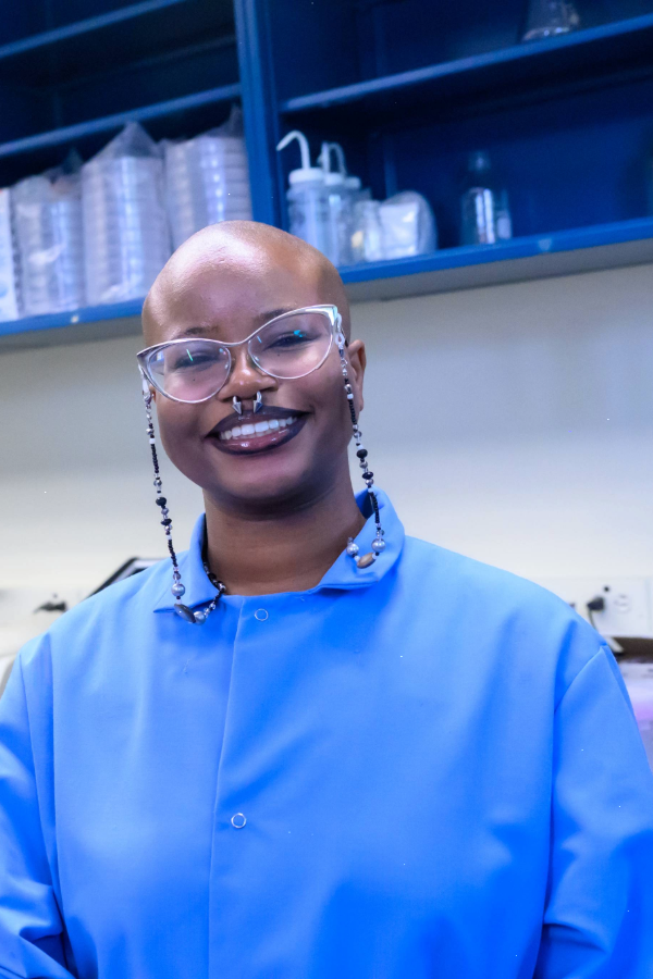 Headshot photo of Rain Lewis in a blue lab coat