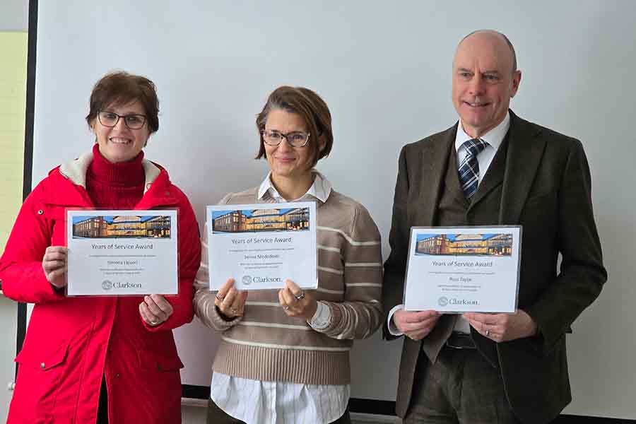 Three Chemical Engineering faculty members at Clarkson University stand side-by-side holding their Years of Service Award certificates. From left to right: Professor Simona Liguori (5 years) in a red jacket, Professor Selma Mededovic Thagard (15 years) in a striped sweater, and Professor Ross Taylor (45 years) in a brown suit.
