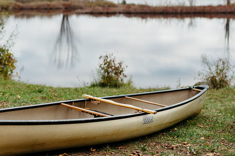 A canoe sits on a bank near the Raquette River near Clarkson University